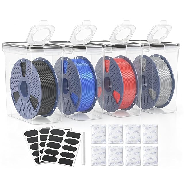 Cuatro cajas transparentes altas con tapa abatible y bobinas dentro, tres hojas de etiquetas negras, un rotulador blanco y ocho sobres de gel de sílice
