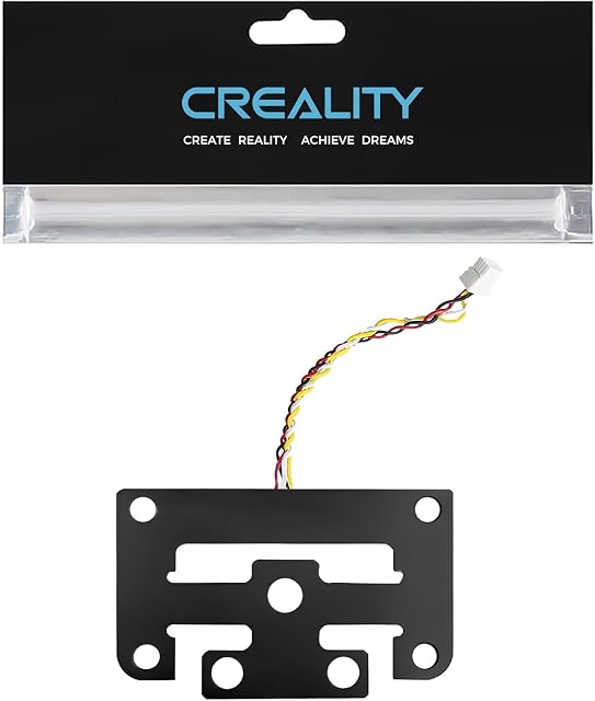 Placa negra de galga extensométrica con orificios para tornillos y un cable de cuatro hilos enchufado, bajo una cabecera de embalaje de Creality